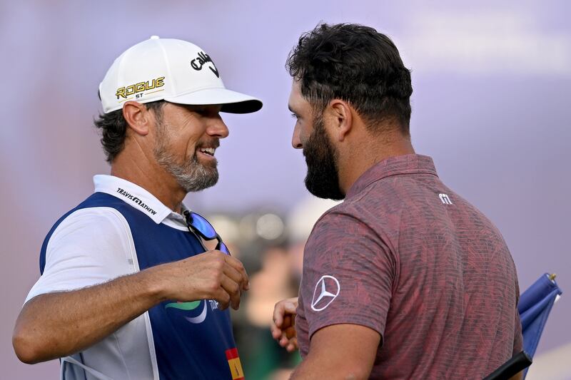 Jon Rahm and caddie Adam Hayes celebrate on the 18th green. Getty