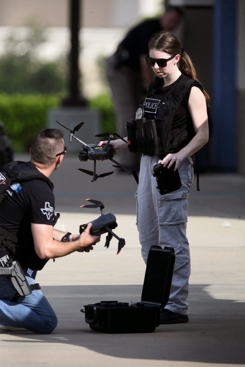 Police officers use drones at the scene of the shooting, in which eight people were killed. AFP 