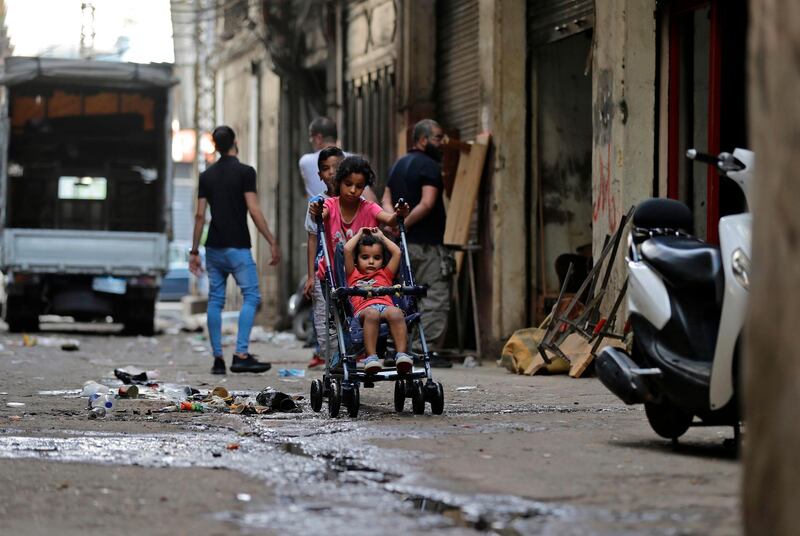 A girl pushes a child stroller with another girl seated, along an alley in the Bab al-Tabbaneh neighbourhood of Lebanon's northern city of Tripoli on June 3, 2020. Thousands of residents of Lebanon's northern Tripoli struggle to put food on the table, as the country's worst economic crisis in decades has picked up in speed in recent weeks, with food prices rising by more than 70 percent since the autumn. Inflation has been a blow in the country where more than 45 percent of the country's population now lives below the poverty line, and more than 35 percent of the workforce is unemployed. / AFP / JOSEPH EID
