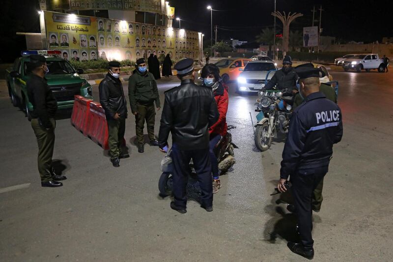 Iraqi police man a checkpoint during a nightime curfew imposed by authorities to curb the spread of the Covid-19.  AFP