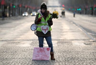 A protester wearing a yellow vest stands before taking part in a demonstration by the "yellow vests" movement on the Champs-Elysees Avenue in Paris, France, December 15, 2018. REUTERS/Benoit Tessier