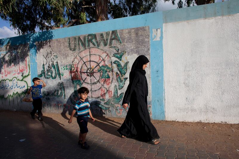 A Palestinian woman and her children outside the walls of the  UNRWA  elementary school in Beach Camp July 14,2014. They fled their home  from Beit Lahiya in northern Gaza as thousands of Palestinians in Gaza fled for safer ground  as Israel threatened a ground invasion and escalated its now six-day campaign of air-strikes to stop rocket fire from the Hamas-run territory. 
Roughly 4,000 residents of northern Gaza had left their homes southward to take refuge in United Nations facilities in Gaza City, said Christopher Gunness, spokesman for the UNÕs Relief and Works Agency for Palestine Refugees (UNRWA). (Photo by Heidi Levine for The National).