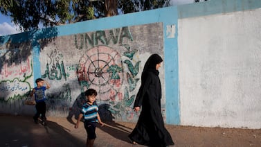 A Palestinian woman and her children outside the walls of the UNRWA elementary school in 2014. Heidi Levine for The National