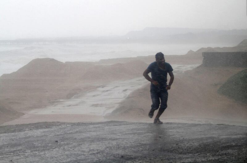 A resident runs through the Arjipalli beach during rain and strong winds caused by Cyclone Titli near Gopalpur on the Bay of Bengal coast, Ganjam district, eastern Orissa state, India. AP Photo