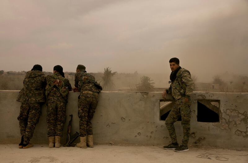 Syrian Democratic Forces soldiers watch from a rooftop the battle to oust Islamic State militants from Baghouz, Syria. AP Photo