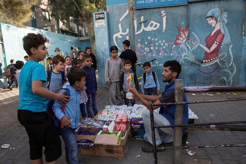 A vendor tries to sell candy to Palestinian school children outside the UNRWA Asma Coed Elementary school in The Shati refugee camp in Gaza City on October 30,2018.Like many other communities, GazaÕs children are also drawn to cheap processed foods, such as bags of chips and candies, he said. Men with makeshift stands wait outside schools to sell children sugary snacks, a moment of sweetness and the only one they can afford.(Photo by Heidi Levine For The National).
