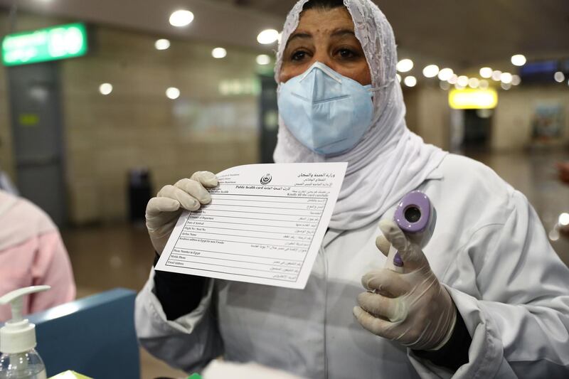 Airport officials screen the temperature of passengers in order to detect a possible coronavirus infection, at Cairo International Airport, in Cairo, Egypt.  EPA