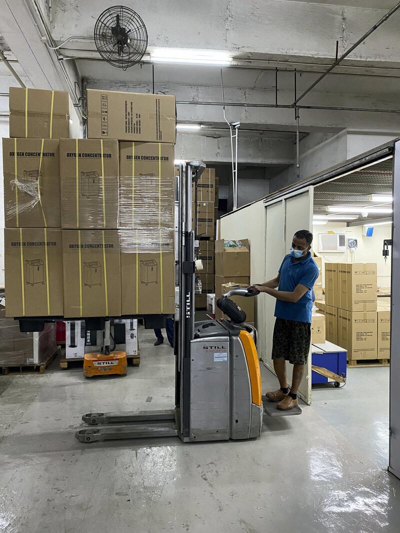 A worker in Hong Kong loads stacks of cartons containing oxygen concentrators that are in demand in India as the country fights to provide medical care to Covid-19 patients.  courtesy Jacky’s Electronics