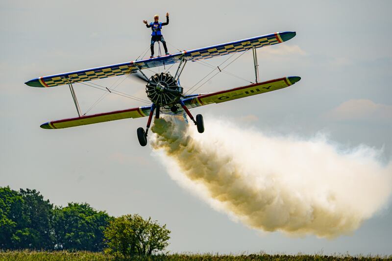 A wingwalker on a 1941 biplane at the AeroSuperBatics WingWalkers team base in Gloucestershire on Tuesday, during a charity event ahead of the airshow season. PA