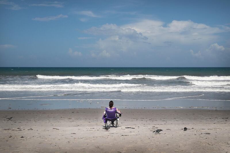 A beachgoer sits in a chair at Indialantic Beach on August 31, 2019 in Indialantic, Florida. Despite the holiday weekend, few people gathered at Indialantic Beach as the area hunkers down in preparation for Hurricane Dorian. Dorian, once expected to make landfall near Indialantic as a category 4 storm, is currently expected to turn north and stay off of the Florida coast, lessening the impact on the area.   Scott Olson/Getty Images/AFP