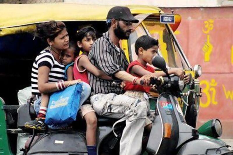 The family-on-a-scooter phenomenon still exists in India despite the advent of more affordable cars. Christophe Archambault / AFP