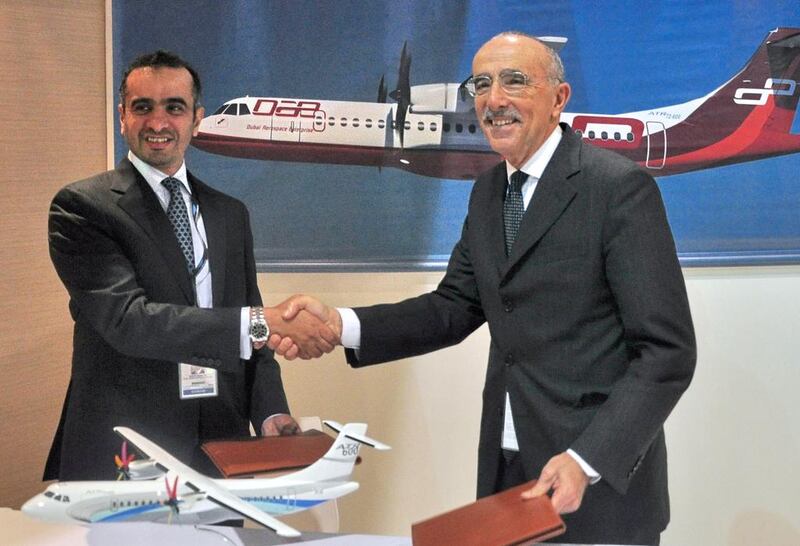 Khalifa Al Daboos, managing director of Dubai Aerospace, left shakes hands with ATR chief executive Filippo Bagnato after signing a nearly US$988 million deal at the Singapore Airshow. Stefanus Ian / AFP