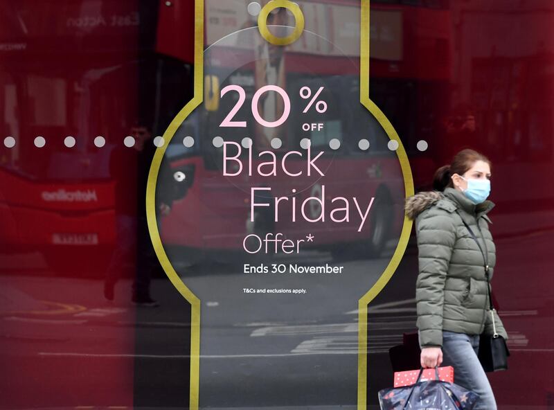 Shoppers walk past a shop announcing Black Friday offers in an unusually quiet Oxford Street. EPA