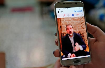 A woman watches the Facebook video of Syrian businessman Rami Makhlouf on her mobile in Syria's capital Damascus, on May 11, 2020. Syria's top tycoon publicly airing his grievances has revealed a power struggle within the ruling family as it tries to cement its power after nine years of war, analysts say. After years of staying out of the limelight, business magnate Rami Makhlouf this month in two videos on Facebook laid bare his struggles with the regime headed by his first cousin President Bashar al-Assad, in what analysts say is a desperate last stand. / AFP / -

