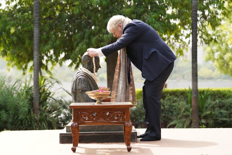Boris Johnson garlands a bust of Mahatma Gandhi on the first day of his official trip to India. Getty Images