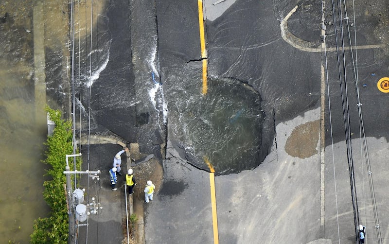 Water flows out from cracks in a road damaged by an earthquake in Takatsuki, Osaka. Reuters