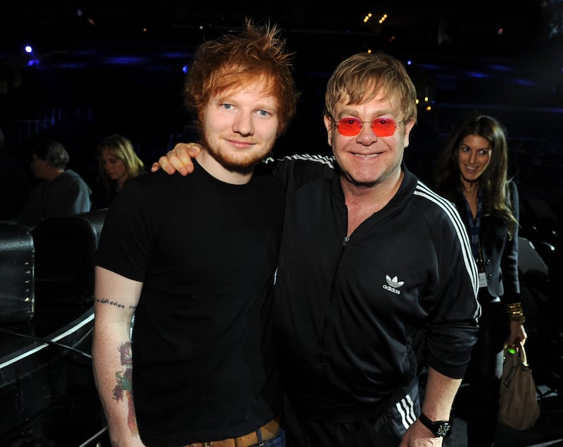 Ed Sheeran and Elton John, in a black Adidas tracksuit, pose backstage during the 55th Annual Grammy Awards at the Staples Centre in Los Angeles, California on February 9, 2013. WireImage