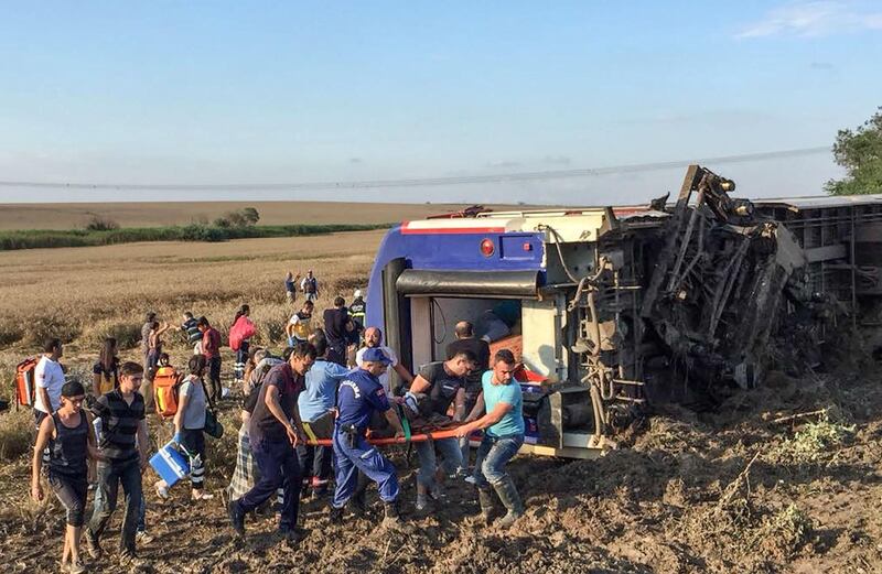 People and rescuers carry an injured woman after a train accident at Corlu district in Tekirdag, on July 8, 2018. Ten people were killed and 73 injured on July 8 when a train packed with weekend passengers derailed in northwest Turkey, sate-run TRT Haber television said, quoting the health ministry. - Turkey OUT
 / AFP / DHA / DHA
