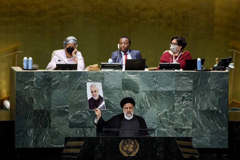 Iranian President Ebrahim Raisi holds up a picture of Qassem Suleimani as he addresses the UN General Assembly. AFP