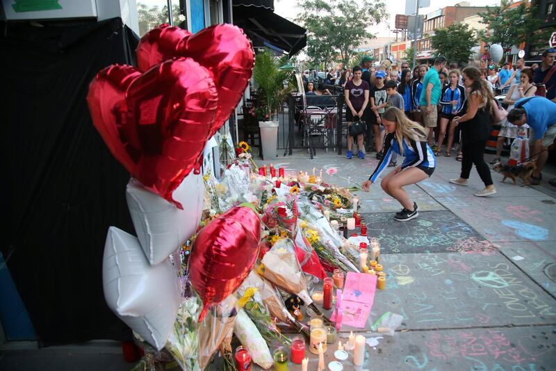 A member of the Markham Synchro Swimming Club pays respect at a makeshift memorial as they take part in a vigil three days after a mass shooting on Danforth Avenue in Toronto, Ontario, Canada, July 25, 2018.  REUTERS/Chris Helgren