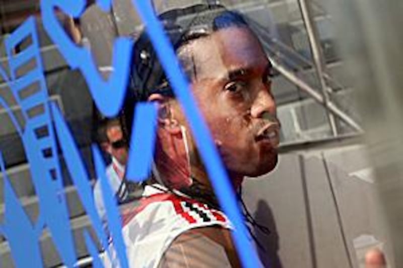 AC Milan's Ronaldinho looks through the glass of a dugout as he gives an interview at the Al Nasr Stadium in Dubai.