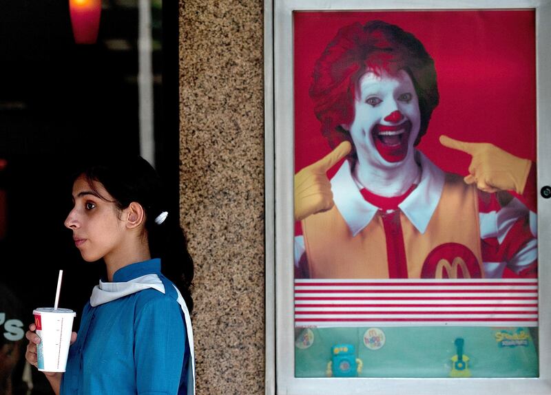 TO GO WITH Lifestyle-India-health-obesity-food,FEATURE by Adam Plowright
In a picture taken on October 4, 2011 a schoolgirl leaves an Indian McDonalds fast food outlet in New Delhi. Every lunch time at a McDonald's on the corner of one of central New Delhi's biggest streets, queues of hungry young patrons, often four-wide and unruly, snake towards the counters. The majority of those standing in line are under 30, most are in Western rather than Indian dress, and almost all in their choice of conversation and style are identifiably part of the much-fabled booming Indian middle class. But the increasing consumption of processed food that is high in fat and sugar is causing worries that India is importing the Western disease of obesity, creating a ticking public health bomb that the country can ill-afford. AFP PHOTO/ MANAN VATSYAYANA / AFP PHOTO / MANAN VATSYAYANA