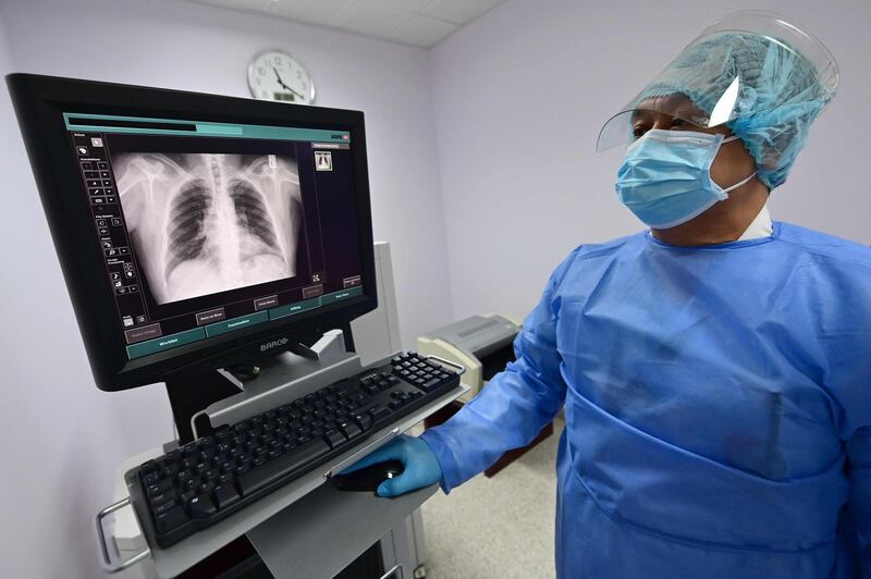 A doctor examines an inmate's x-ray at the medical centre. Video conferencing is being used to cut down on face to face interactions