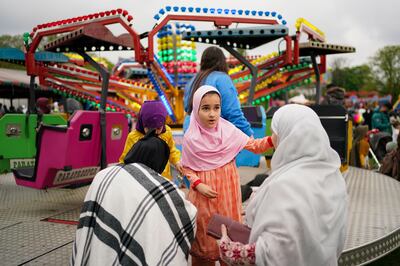 People enjoy theme park rides at a park in Birmingham, to celebrate Eid, on May 2.
