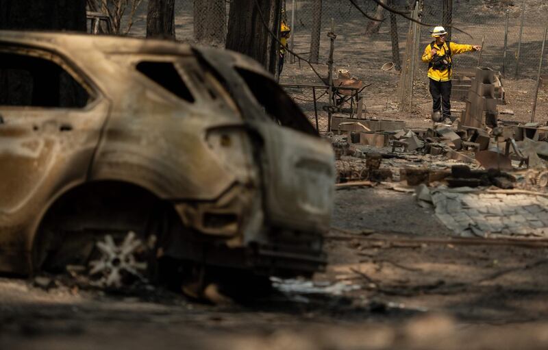Firefighters search through a burned residence after the passage of the Bear fire, part of the larger North Lightning Complex fire, in the Berry Creek area of unincorporated Butte county, California.  AFP