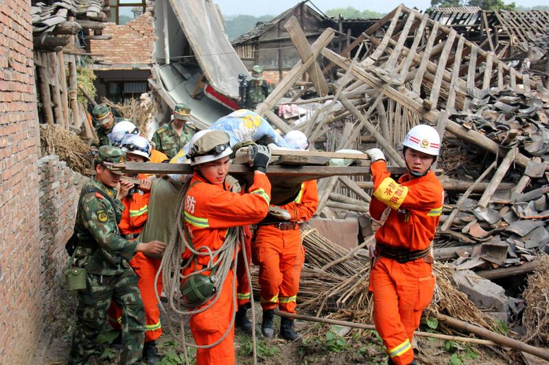 In this photo released by China's Xinhua News Agency, rescuers carry out an elderly paralyzed person from a collapsed house after an earthquake struck, in Qingren Township, Lushan County, Ya'an City, southwest China's Sichuan Province, Saturday, April 20, 2013. A powerful earthquake struck the steep hills of China's southwestern Sichuan province Saturday morning, leaving at least 160 people dead and more than 6,700 injured. (AP Photo/Xinhua, Le Xiaoxuan) NO SALES *** Local Caption ***  China Earthquake.JPEG-08360.jpg