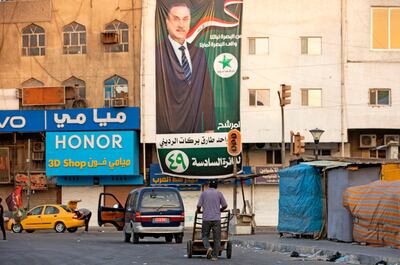 An Iraqi man walks past electoral campaign posters on October 6, 2021 in the southern city of Basra. AFP