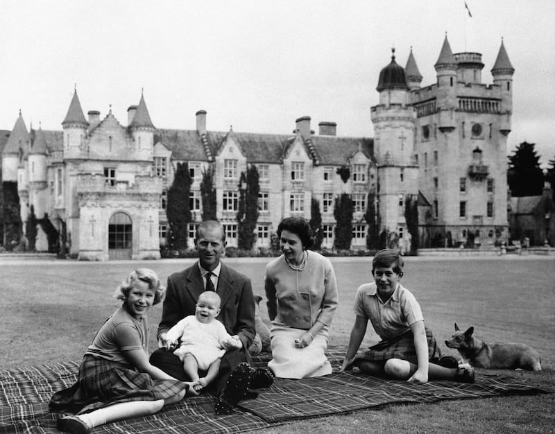 Britain's Queen Elizabeth II, Prince Philip and their children, Prince Charles, right, Princess Anne and Prince Andrew, pose for a photo on the lawn of Balmoral Castle, in Scotland, in September 1960. AP Photo