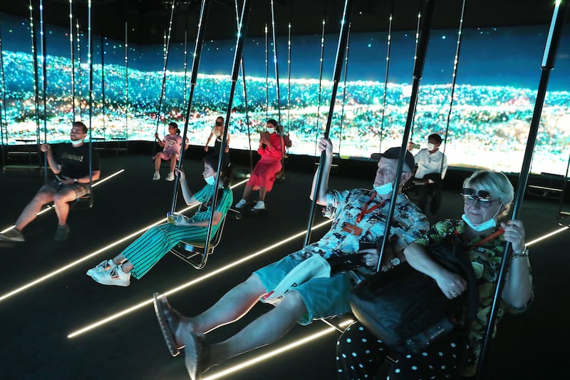 Visitors swinging in the graduation hall at the Germany pavilion. Pawan Singh / The National  