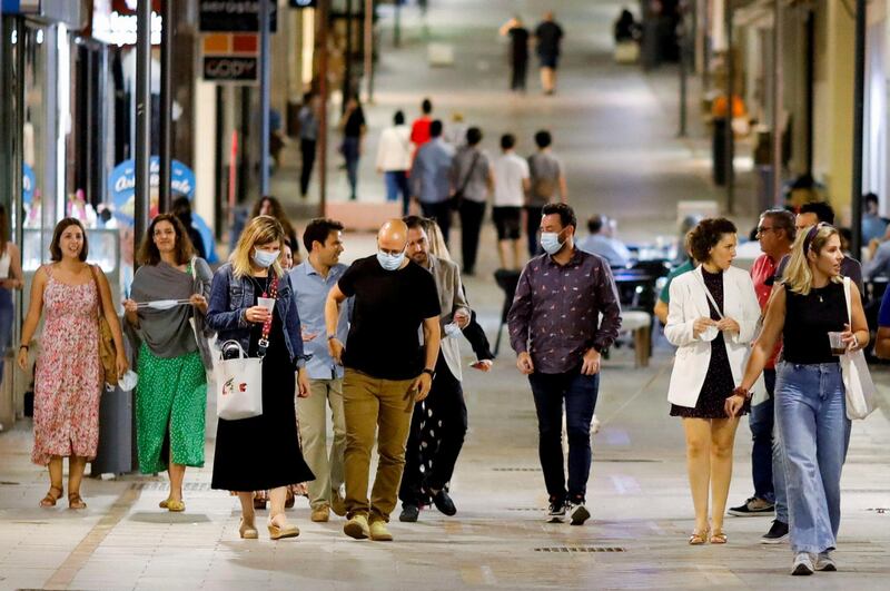 Pedestrians with and without masks walk along La Bola, in Ronda, Andalusia, in southern Spain, after the government eased Covid-19 restrictions. Reuters