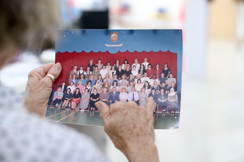 Veteran teacher Jo Fahey holds an image from the 1990s.