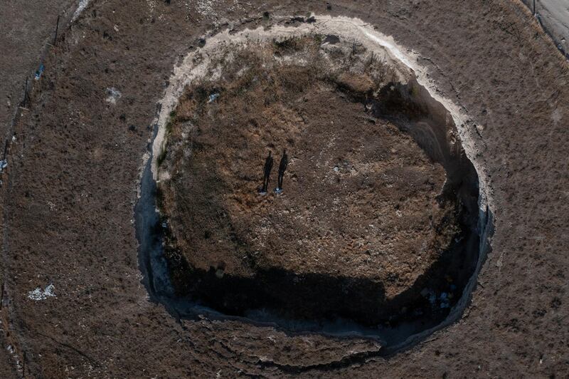 The tiny figures of geologists Fetullah Arik and Arif Delikana illustrate the scale of a giant sinkhole.