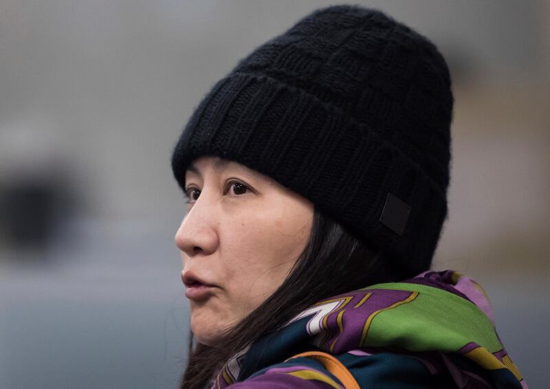 Huawei chief financial officer Meng Wanzhou talks with a member of her private security detail after they went into a wrong building while arriving at a parole office in Vancouver, British Columbia, Wednesday, Dec. 12, 2018. (Darryl Dyck/The Canadian Press via AP)