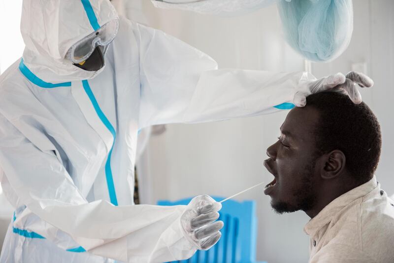 An infectious disease specialist, left, takes a sample from Dr Reagan Taban Augustino, now a coronavirus patient himself under quarantine, at the Dr John Garang Infectious Diseases Unit in Juba, South Sudan, June 21. The UN says the country's outbreak is growing rapidly, with nearly 1,900 cases, including more than 50 health workers infected, and at the only laboratory in the country that tests for the virus a team of 16 works up to 16-hour days slogging through a backlog of more than 5,000 tests. Charles Atiki Lomodon/ AP