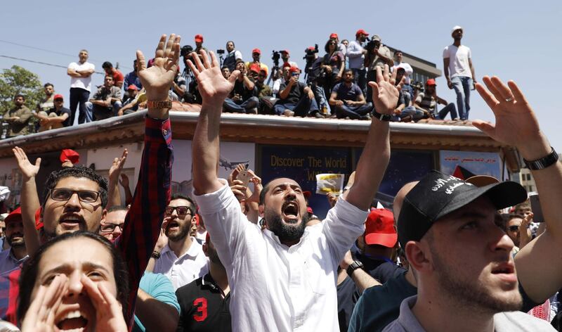 Jordanian protesters chant slogans during an anti-austerity rally, on June 6, 2018, in front of the Labor Union offices in Amman. Jordanian unions staged a nationwide strike today over IMF-backed austerity measures including a proposed income tax law that has sparked a week of angry demonstrations. / AFP / AHMAD GHARABLI

