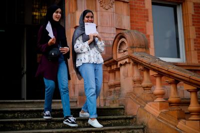 Students at Newham Collegiate Sixth Form react after receiving their A-Level results in east London on August 13, 2020. English authorities reassured school pupils they would be graded fairly for exams missed because of the coronavirus, after the Scottish government was forced into a major U-turn on the issue. / AFP / Tolga Akmen
