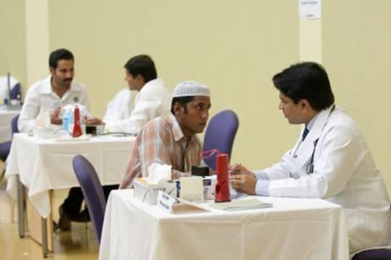 August 12, 2011 - Labourers speak with doctors at the ASTER organized Health clinic held at Etisalat Academy in Dubai, United Arab Emirates. Pawel Dwulit / The National
