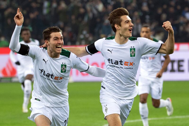 Monchengladbach's Florian Neuhaus, right, celebrates levelling the scores with teammate Joe Scally. AP