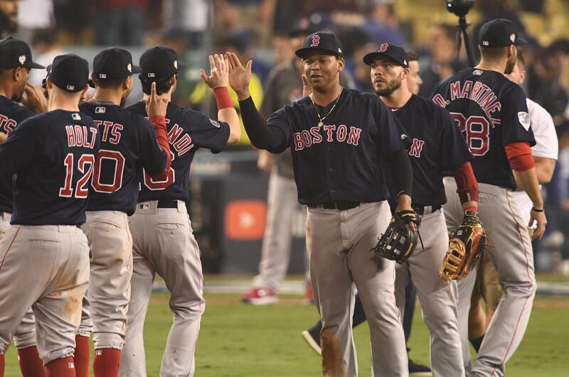 Oct 27, 2018; Los Angeles, CA, USA; Boston Red Sox third baseman Rafael Devers (middle) celebrates with teammates after defeating the Los Angeles Dodgers in game four of the 2018 World Series at Dodger Stadium. Mandatory Credit: Robert Hanashiro-USA TODAY Sports