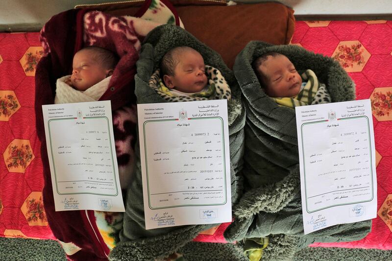 TOPSHOT - A picture taken on February 2, 2018 shows three Palestinian newborn triplets of the al-Saiqli family, named (R to L) "Quds" (Arabic for Jerusalem), "Palestine", and "Capital", as they lie sleeping with their birth certificates placed above them, in the southern Gaza strip city of Khan Yunis.
Palestinians have reacted to Donald Trump's recognition of Jerusalem as Israel's capital with street protests, but one couple have come up with an idea of their own, in the naming of their triplets. / AFP PHOTO / SAID KHATIB