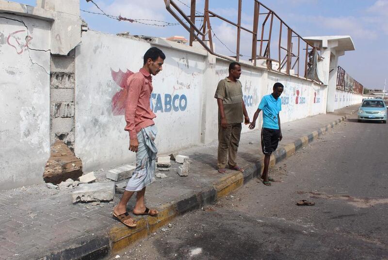 Yemenis stand at the site where a bomb attack killed five army recruits in the southern city of Aden on April 12, 2016. Saleh Al Obeidi / AFP