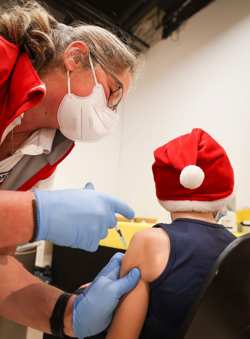 A boy wearing a Christmas hat is vaccinated in a shopping centre near Hamburg, Germany. AP