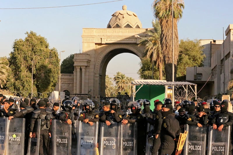 Iraqi security forces stand outside the main gate of Baghdad's Green Zone as demonstrators protest against the nomination of Mohammed Shia Al Sudani as prime minister. AFP