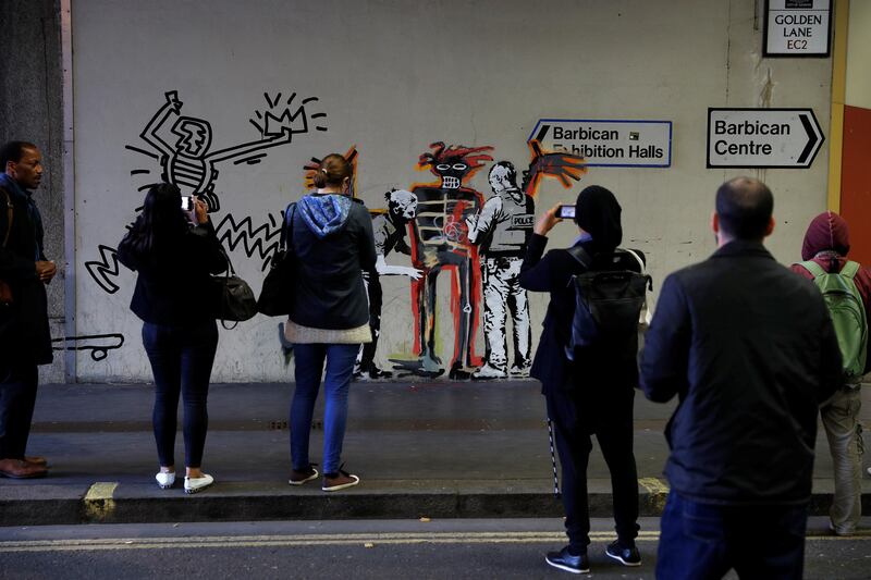 People look as others photograph a mural painted by the artist Banksy near the Barbican Centre in London, Britain, September 18, 2017. REUTERS/Peter Nicholls  NO RESALES. NO ARCHIVES