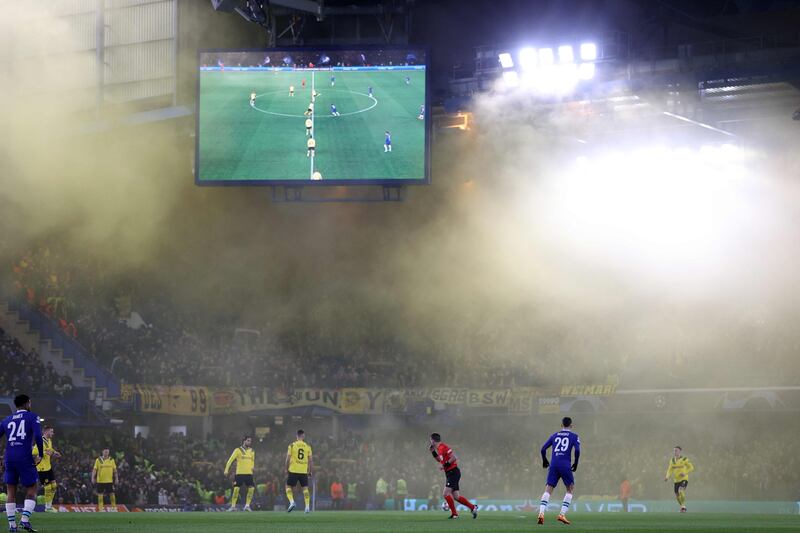 Yellow smoke form flares let off by Dortmund fans fills Stamford Bridge. AFP