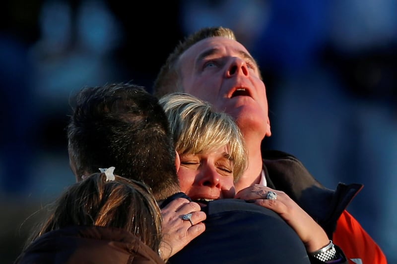 Lynn and Christopher McDonnell, the parents of seven-year-old Grace McDonnell, grieve near Sandy Hook Elementary after learning their daughter was one of 20 school children and six adults killed after a gunman opened fire inside the school in Newtown, Connecticut. Picture taken December 14, 2012. Adrees Latif / Reuters